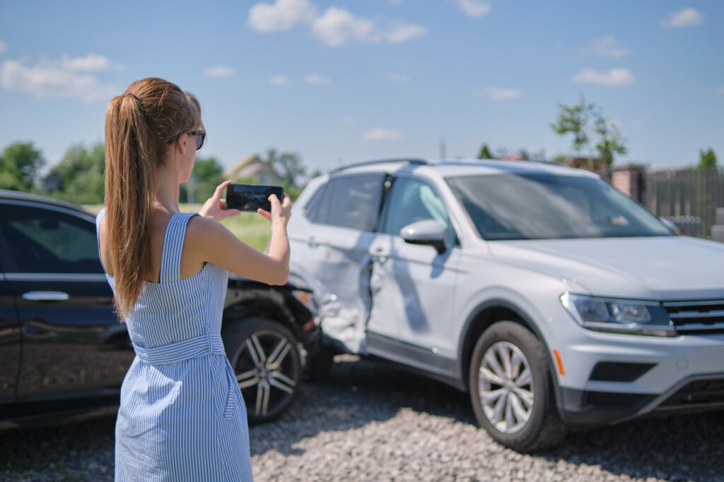 Woman takes photos following a car accident