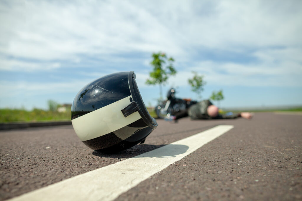 La víctima de la motocicleta yace en el suelo: las marcas de la carretera son una lesión común en caso de accidente.