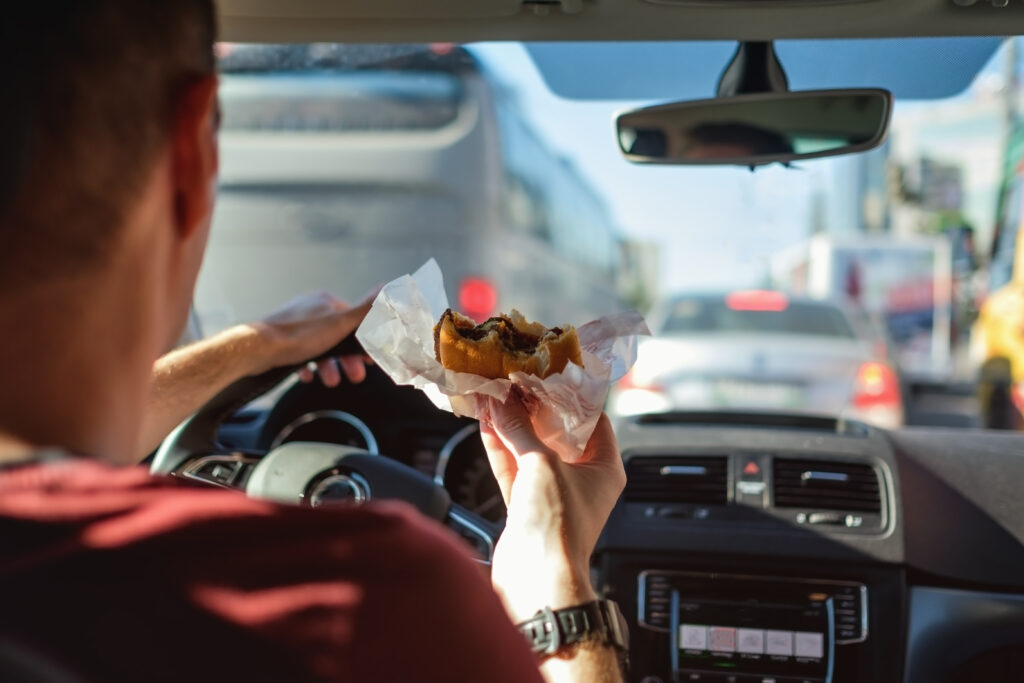 A man eating food while driving